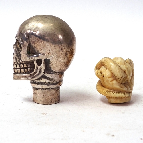 99 - A 19th century carved ivory hand holding snake parasol handle tip, and a silver plated skull walking... 