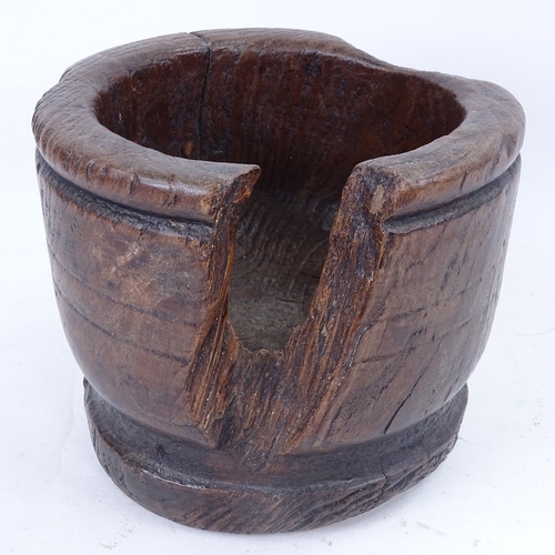 180 - An 18th century turned wood mortar, diameter 23cm, chunk missing and stapled