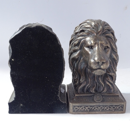 231 - A pair of composition lion-head bookends, resin Pointer dog sculpture, and resin dog in shoe sculptu... 