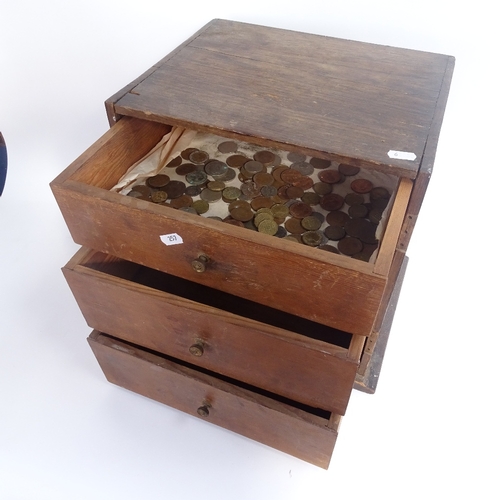 257 - An engineer's table-top oak chest of drawers, containing various British pre-decimal coins, chest he... 