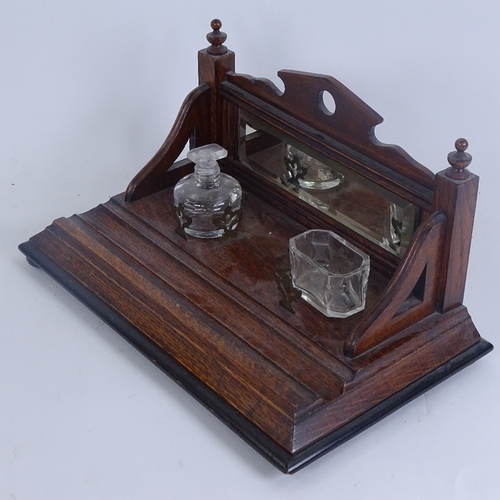 263 - An oak desk stand, with raised bevel-edge mirrored back, 2 inkwells and pen tray, stand length 30cm