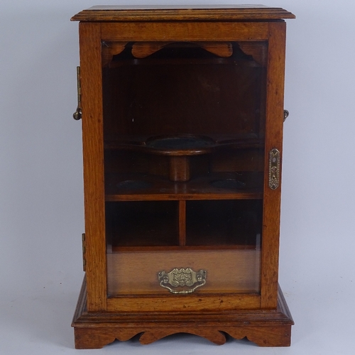 264 - A Victorian oak smoker's display cabinet, with brass swing handles, glazed door and fitted interior,... 