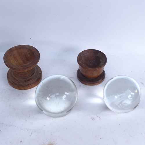 404 - A graduated set of 5 clear glass crystal balls on wood stands, largest and smallest diameters 10cm a... 