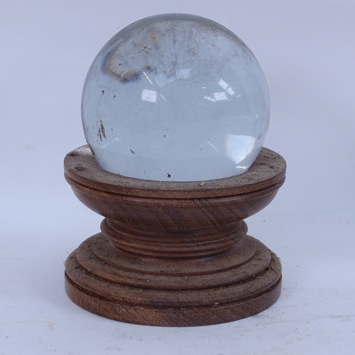 404 - A graduated set of 5 clear glass crystal balls on wood stands, largest and smallest diameters 10cm a... 