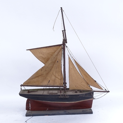 409 - A handmade carved and painted wood pond yacht, with string rigging and canvas sails, hull length 43c... 