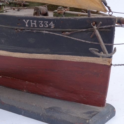 409 - A handmade carved and painted wood pond yacht, with string rigging and canvas sails, hull length 43c... 