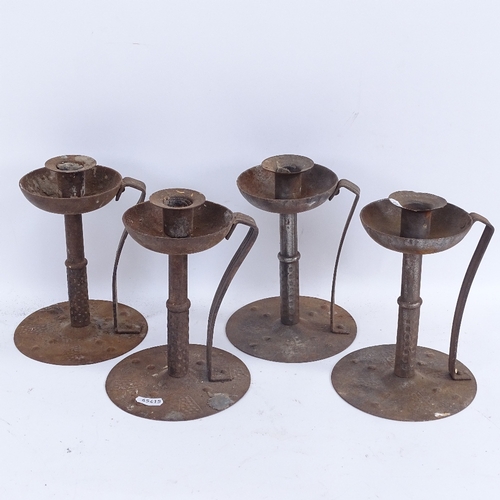 433 - A set of 4 German Arts and Crafts Hugo Berger iron table candlesticks, hammered bases and stems with... 