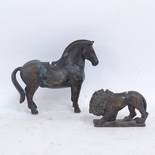 585 - A heavy cast-brass horse and lion, horse length 17cm (2)