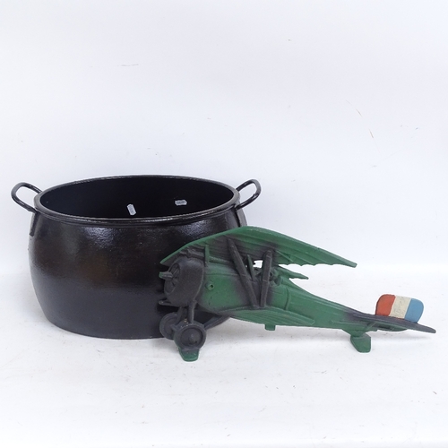 594 - A cast-iron 4 gallon caldron, and a painted cast-iron biplane ornament, length 50cm (2)