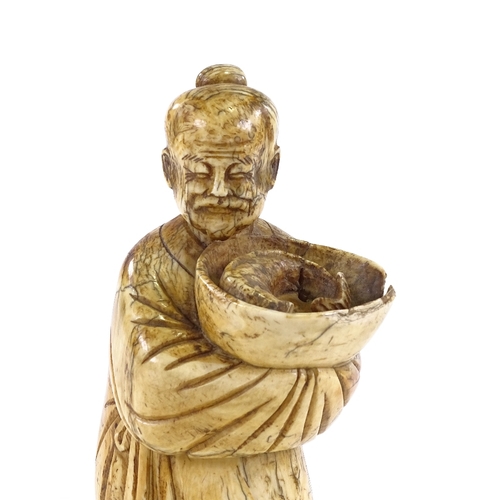 93 - A Chinese carved ivory figure of a man holding a fish in a bowl, 18th/19th century, height 18cm.