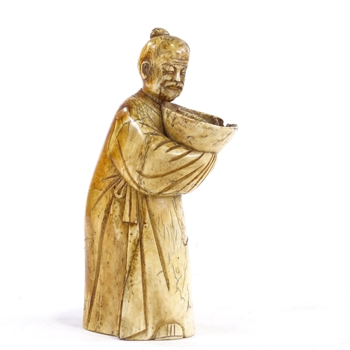 93 - A Chinese carved ivory figure of a man holding a fish in a bowl, 18th/19th century, height 18cm.