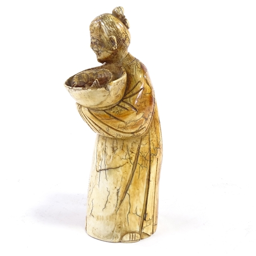 93 - A Chinese carved ivory figure of a man holding a fish in a bowl, 18th/19th century, height 18cm.