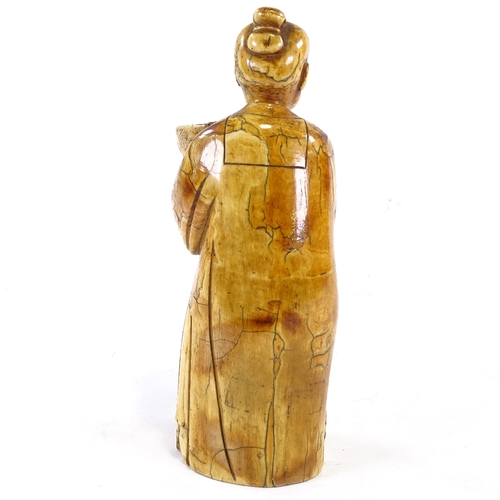 93 - A Chinese carved ivory figure of a man holding a fish in a bowl, 18th/19th century, height 18cm.