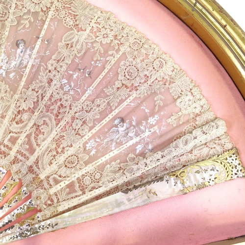 109 - A hand painted lace fan, with carved mother of pearl and ivory sticks, in frame, frame width 76cm.