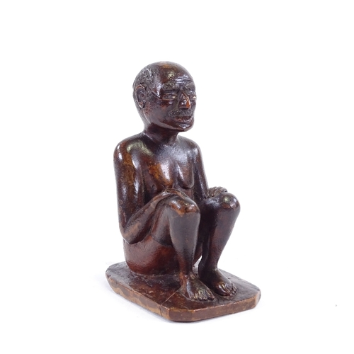 120 - An Indian 19th century wood carving of a seated man, height 9.5cm