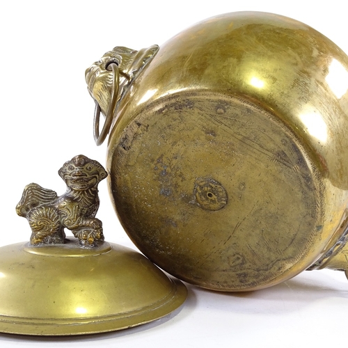 68 - A Chinese polished bronze bowl and cover with lion ring handles, surmounted by a Dog of Fo, height 2... 