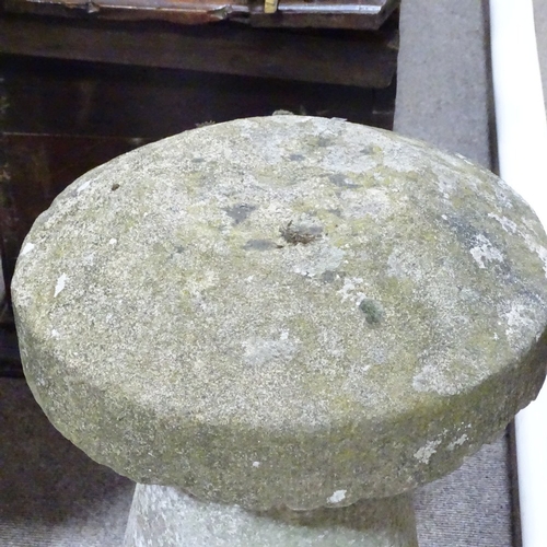 116 - A weathered stone saddle stone, height 74cm, diameter 41cm