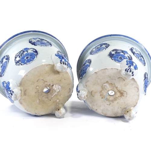 32 - A pair of Japanese Meiji period blue and white porcelain jardinieres, with relief flower panels and ... 