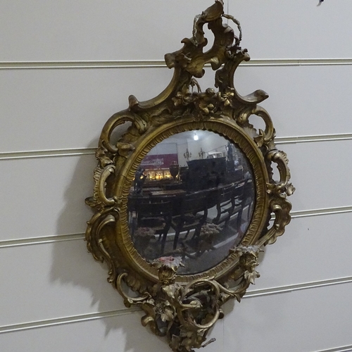 71 - An ornate gilt-gesso framed convex wall mirror with twin candle brackets, overall height 90cm