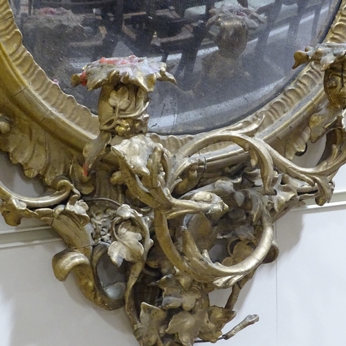 71 - An ornate gilt-gesso framed convex wall mirror with twin candle brackets, overall height 90cm