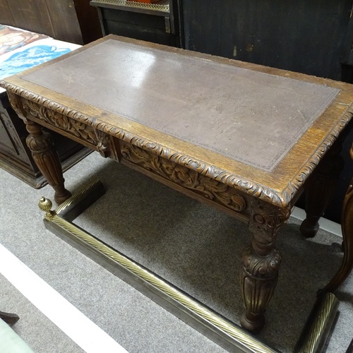 96 - A Victorian Carolean style oak library writing table, with frieze drawers, inset leather top on carv... 