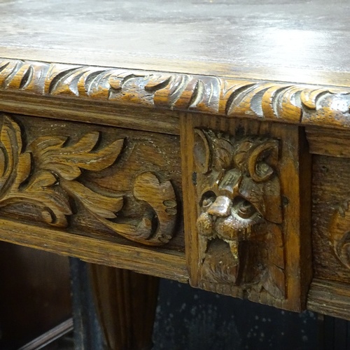 96 - A Victorian Carolean style oak library writing table, with frieze drawers, inset leather top on carv... 