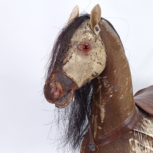28 - An antique German child's push-along horse toy, pony-skin covered with horse hair mane and tail, on ... 