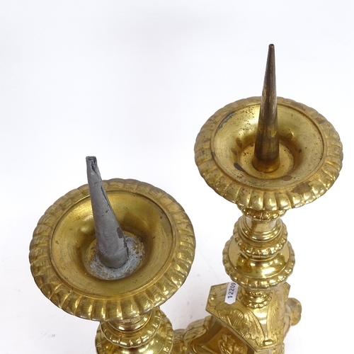 56 - A pair of cast-brass pricket candlesticks, relief embossed religious portraits and scenes, overall h... 
