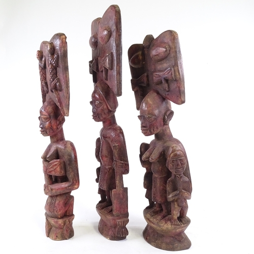 203 - 3 carved wood African figures, stained red, tallest 64cm.