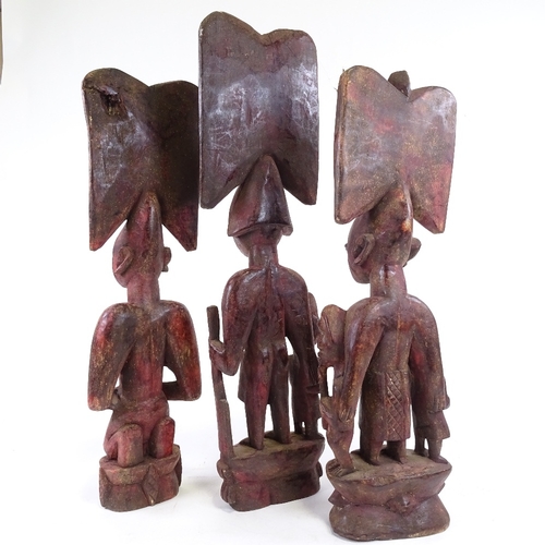 203 - 3 carved wood African figures, stained red, tallest 64cm.