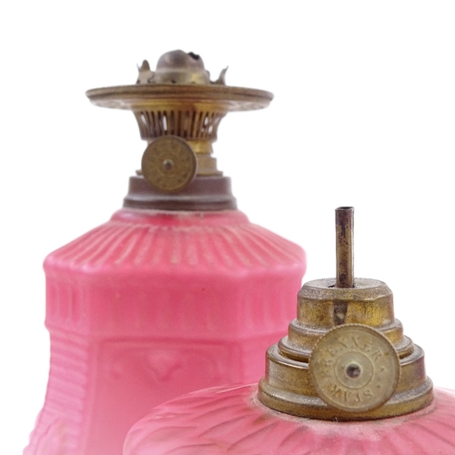 33 - A pair of Victorian pink satin glass oil lamps of small size, relief moulded decoration and original... 