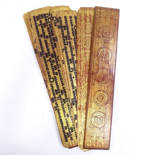 68 - A 19th century Burmese palm leaf prayer book, with gilded and lacquered wood covers, length 55cm