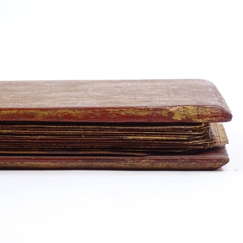 68 - A 19th century Burmese palm leaf prayer book, with gilded and lacquered wood covers, length 55cm