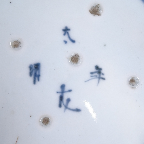 71 - A Japanese blue and white porcelain plate with hand painted figures, 4 character mark, diameter 29cm