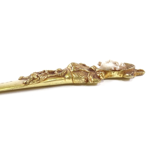 81 - A gilt-bronze and ivory paper knife, the relief cast handle in the form of a Victorian lady, unsigne... 