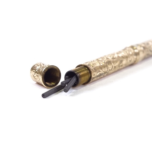 88 - A 9ct gold dual propelling pen/pencil, with engraved decoration, marked 9ct, open pen length 12cm.