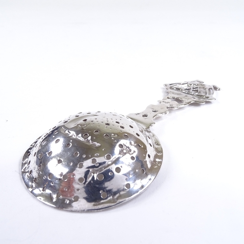 535 - A German silver tea strainer, pierced ship design handle and bowl with foliate stem, length 13cm, 1o... 