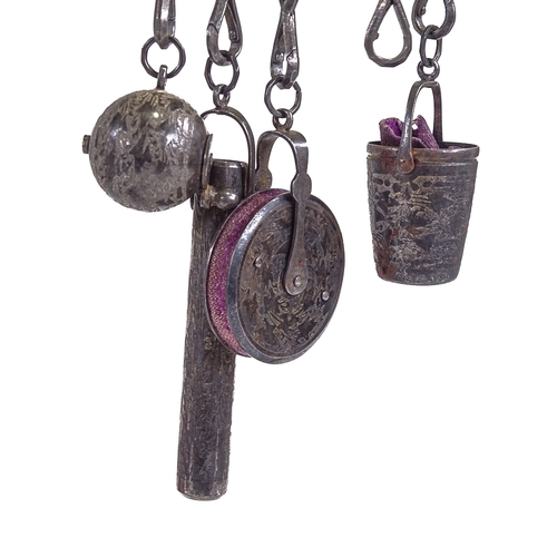 537 - A 19th century bright-cut steel chatelaine, target-shaped clip suspending 6 steel chains with thimbl... 