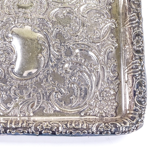 559 - An Edwardian rectangular silver dressing table tray, relief embossed foliate and floral decoration w... 