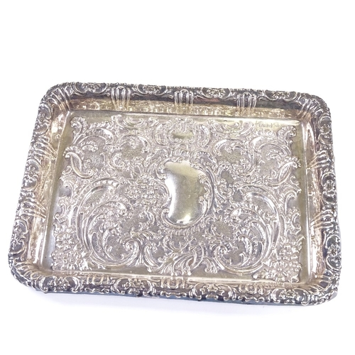 559 - An Edwardian rectangular silver dressing table tray, relief embossed foliate and floral decoration w... 