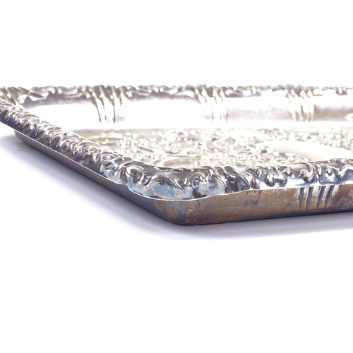 559 - An Edwardian rectangular silver dressing table tray, relief embossed foliate and floral decoration w... 