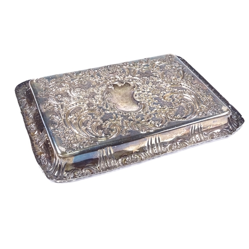 559 - An Edwardian rectangular silver dressing table tray, relief embossed foliate and floral decoration w... 