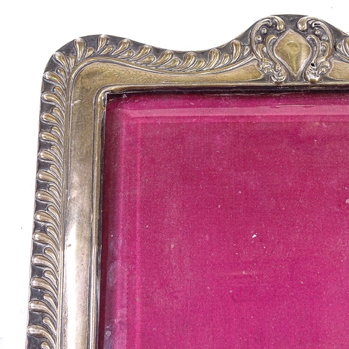 564 - A late Victorian silver-fronted rectangular photo frame, relief embossed fluted and foliate decorati... 