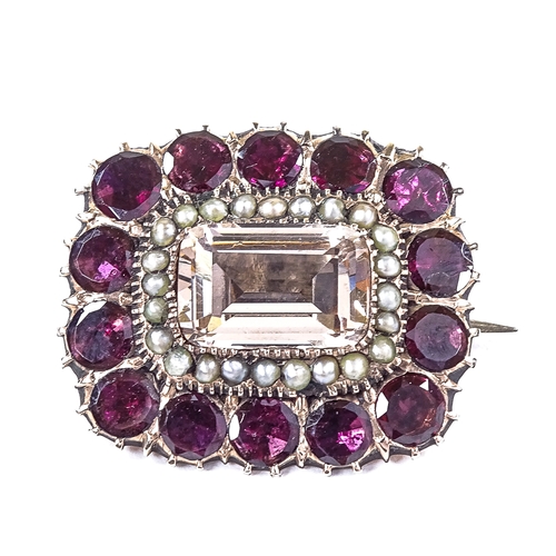 565 - A 19th century unmarked gold paste flat-top garnet and seed pearl memorial brooch, closed back setti... 