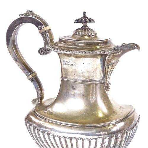 567 - An Edwardian silver coffee pot, half-fluted oval baluster form with ebonised knop and ivory insulato... 