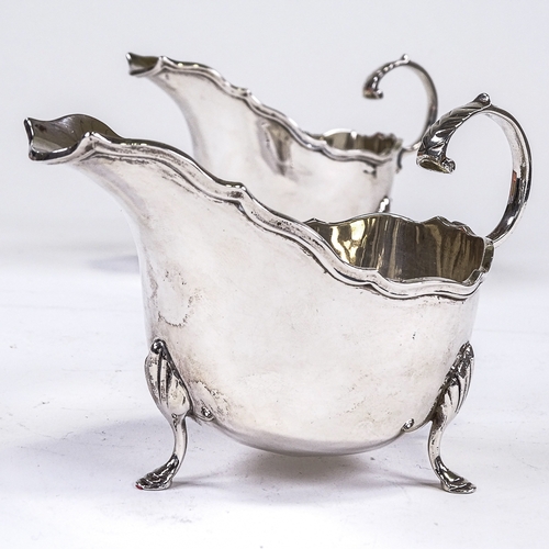 571 - A pair of George V silver sauce boats, cast scalloped lip with hoof feet and C-shaped handle, by Cha... 