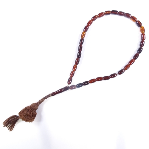 603 - A single strand of amber prayer beads, with hand knotted tassel, bead length 12.4mm, necklace length... 