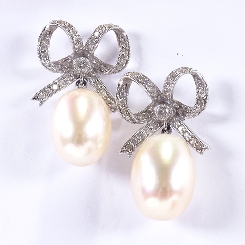 618 - A pair of unmarked white gold diamond and pearl bow drop earrings, earring height 26.3mm, 8.7g total