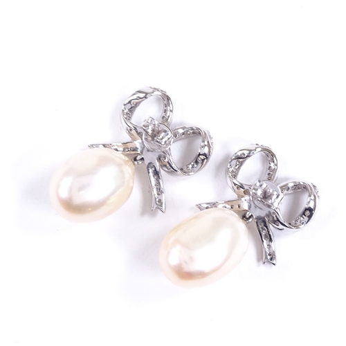 618 - A pair of unmarked white gold diamond and pearl bow drop earrings, earring height 26.3mm, 8.7g total