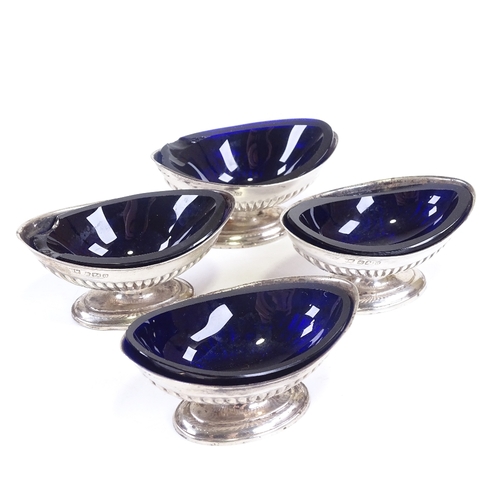 632 - A set of 4 late Victorian silver salt cellars, marquise half-fluted form with blue glass liners, by ... 